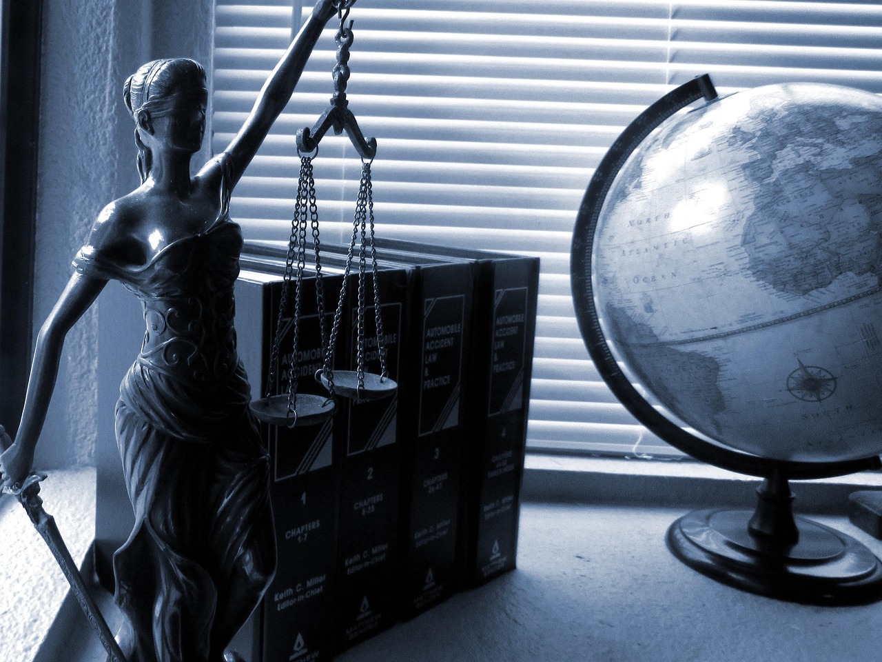 Lady of Justice neben einem Globus und Gesetzesbüchern